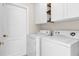 Functional laundry room with a washer, dryer, white cabinets, and a door for easy access at 14617 Keelford Way, Orlando, FL 32824