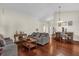 Open concept living room with wood floors, comfortable seating, and dining space beyond at 14617 Keelford Way, Orlando, FL 32824