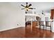 Open-concept living room featuring hardwood floors, ceiling fan, and an adjoining kitchen with barstool seating at 14617 Keelford Way, Orlando, FL 32824