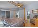 Bedroom featuring a wooden canopy bed, light fixture and view into the bathroom at 14651 Pine Cone Trl, Clermont, FL 34711