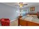 Cozy bedroom with a wooden framed bed, ceiling fan, and a sun-filled window at 14651 Pine Cone Trl, Clermont, FL 34711