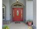 Charming red front door with sidelights and an arched transom window at 14651 Pine Cone Trl, Clermont, FL 34711