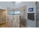 Modern walk-in shower with gray marbled tile surround and a window for natural light at 14651 Pine Cone Trl, Clermont, FL 34711