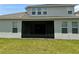 Rear exterior showcasing the screen patio and lush backyard at 15161 Lake Bessie Loop, Winter Garden, FL 34787