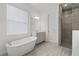 Bright bathroom with tub and tiled shower with glass enclosure at 15161 Lake Bessie Loop, Winter Garden, FL 34787