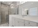 Sleek bathroom featuring a glass shower, vanity with dual sinks, and a modern aesthetic at 15161 Lake Bessie Loop, Winter Garden, FL 34787