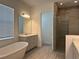 A spacious bathroom features double vanity, freestanding tub and luxurious walk-in shower at 15161 Lake Bessie Loop, Winter Garden, FL 34787