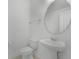 Modern powder room features a stylish pedestal sink and round mirror at 15161 Lake Bessie Loop, Winter Garden, FL 34787