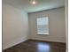 Bright bedroom featuring wood floors, a window with blinds, and neutral paint at 15161 Lake Bessie Loop, Winter Garden, FL 34787