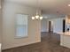 Bright dining area featuring new dark flooring, neutral paint, and a modern chandelier at 15161 Lake Bessie Loop, Winter Garden, FL 34787