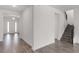 Bright entryway featuring wood-look floors, stairs with iron railing, and a view of the front door at 15161 Lake Bessie Loop, Winter Garden, FL 34787