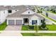 Charming home with a brick driveway, a two-car garage, and a well-maintained front yard with lovely landscaping at 15161 Lake Bessie Loop, Winter Garden, FL 34787