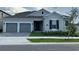 Charming single-story home with a two-car garage, manicured lawn, and traditional architectural details at 15161 Lake Bessie Loop, Winter Garden, FL 34787