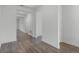 A view of the hallway featuring wood-look floors, neutral walls, and doors to various rooms in the house at 15161 Lake Bessie Loop, Winter Garden, FL 34787