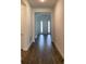 Hallway view featuring new dark floors, neutral paint, and natural light from the entryway at 15161 Lake Bessie Loop, Winter Garden, FL 34787