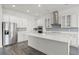 Contemporary kitchen with white cabinets, stainless steel appliances, quartz countertops, and wood-look floors at 15161 Lake Bessie Loop, Winter Garden, FL 34787