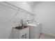 Functional laundry room with stainless steel sink, storage cabinet, and shelving unit at 15161 Lake Bessie Loop, Winter Garden, FL 34787