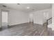 Spacious living room with wood-look floors, neutral walls, multiple doorways, and a staircase at 15161 Lake Bessie Loop, Winter Garden, FL 34787