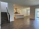 View of the living room featuring stairs and a kitchen with an island and stainless steel appliances at 15161 Lake Bessie Loop, Winter Garden, FL 34787