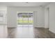Living room with hardwood floors and sliding glass doors that lead to the outdoors at 15161 Lake Bessie Loop, Winter Garden, FL 34787