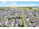 Expansive aerial shot displaying a community of neatly arranged homes with manicured lawns under a sunny sky at 15161 Lake Bessie Loop, Winter Garden, FL 34787