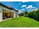 Expansive backyard featuring lush green lawn, covered patio and outdoor play structure at 15698 Panther Lake Dr, Winter Garden, FL 34787