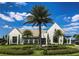 Beautifully landscaped clubhouse with manicured grounds, palm trees, and blue skies at 15698 Panther Lake Dr, Winter Garden, FL 34787