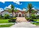 Beautiful home with a red tile roof, palm trees, and lovely landscaping at 15698 Panther Lake Dr, Winter Garden, FL 34787