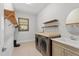 Spacious laundry room equipped with washer, dryer, sink, and shelving for storage at 15698 Panther Lake Dr, Winter Garden, FL 34787