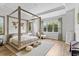 Serene main bedroom features a four-poster bed, hardwood floors, and ample natural light at 15698 Panther Lake Dr, Winter Garden, FL 34787