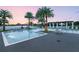 Beautiful pool area with lounge chairs, tables, and palm trees overlooking the lake at 15698 Panther Lake Dr, Winter Garden, FL 34787