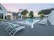 Resort-style community pool with lounge chairs, palm trees, and serene views at 15698 Panther Lake Dr, Winter Garden, FL 34787