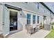 Back patio with seating area, open door into home, and an AC unit on a sunny day at 1615 Sanibel Dr, Davenport, FL 33896