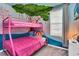 Charming bedroom featuring pink bunk beds, mural art, and natural light from the window at 1615 Sanibel Dr, Davenport, FL 33896