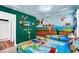 Themed bedroom with twin beds, mural art, and a wall-mounted TV for entertainment at 1615 Sanibel Dr, Davenport, FL 33896