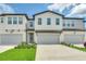 Charming townhome featuring a modern exterior, well-maintained landscaping, and a private garage at 1615 Sanibel Dr, Davenport, FL 33896