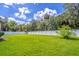 Lush green backyard with a white privacy fence and mature trees, perfect for outdoor activities and relaxation at 1676 Song Sparrow Ct, Sanford, FL 32773
