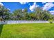 Expansive backyard featuring a swing set, lush green grass, and a white privacy fence, ideal for Gathering enjoyment at 1676 Song Sparrow Ct, Sanford, FL 32773
