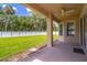 Covered patio showcasing a ceiling fan overlooking a large grassy backyard with a white fence for privacy at 1676 Song Sparrow Ct, Sanford, FL 32773