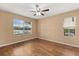 A bedroom with wood floors and two windows allows for natural light at 1979 Summer Club Dr # 115, Oviedo, FL 32765