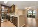 Modern kitchen with stainless steel appliances, wood cabinets, and a breakfast bar at 1979 Summer Club Dr # 115, Oviedo, FL 32765