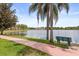 Picturesque view of the lake, with a walking path, palm trees, and building in the background at 1979 Summer Club Dr # 115, Oviedo, FL 32765