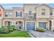 Charming townhome featuring stone accents, a well-manicured lawn, and a delightful garden area at 2039 Beachberry Ln, Oviedo, FL 32765