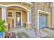 Inviting front porch with elegant columns, stone accents, and a charming floral wreath on the door at 2039 Beachberry Ln, Oviedo, FL 32765