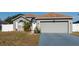 Charming single-story home featuring a well-manicured lawn, arched window, and two-car garage at 212 Ashford Dr, Davenport, FL 33837