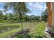 Spacious backyard with lush green grass, a picturesque pond view, and a sturdy chain-link fence at 2330 Little Gem Loop, Sanford, FL 32773