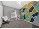 A colorful bedroom featuring a geometric wall, carpeted flooring and modern chair at 2330 Little Gem Loop, Sanford, FL 32773