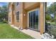 Covered patio features sliding glass doors and a well-maintained lawn leading to a lush backyard at 2330 Little Gem Loop, Sanford, FL 32773