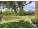Scenic pond view with lush greenery, and a black chain link fence, creating a tranquil outdoor space at 2330 Little Gem Loop, Sanford, FL 32773