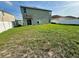 Large backyard with grass, a white fence, and the exterior of the home at 235 Hibiscus St, Winter Haven, FL 33881